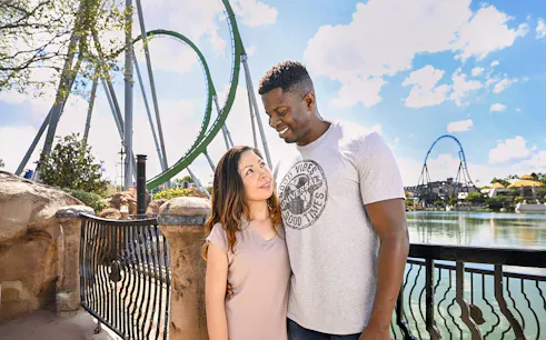 Couple posing with rollercoaster in background at Universal Studios Orlando.