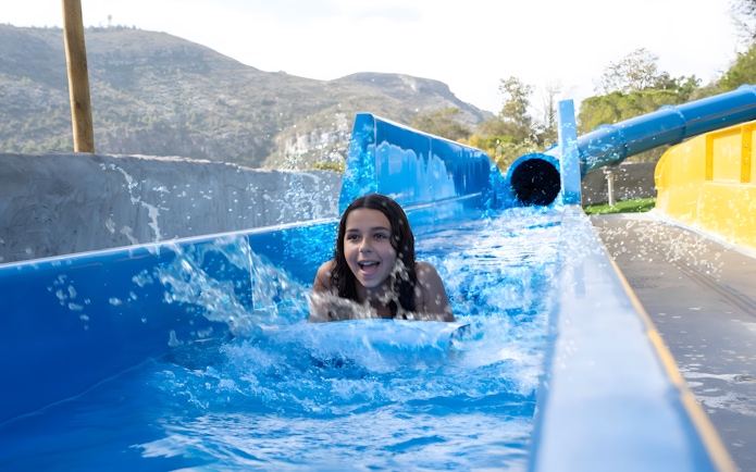 Child enjoying the Black Hole slide at Aquopolis Cullera water park.