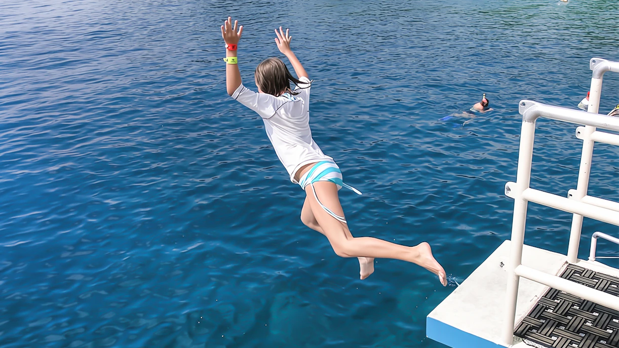 Person jumping off a boat into Kealakekua Bay for an afternoon snorkel.