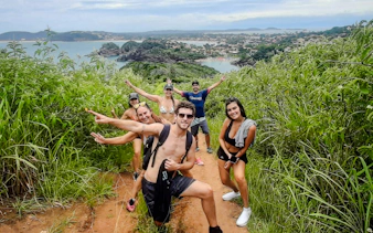 Group hiking in lush greenery with ocean view, Emerências and José Gonçalves, Rio de Janeiro.