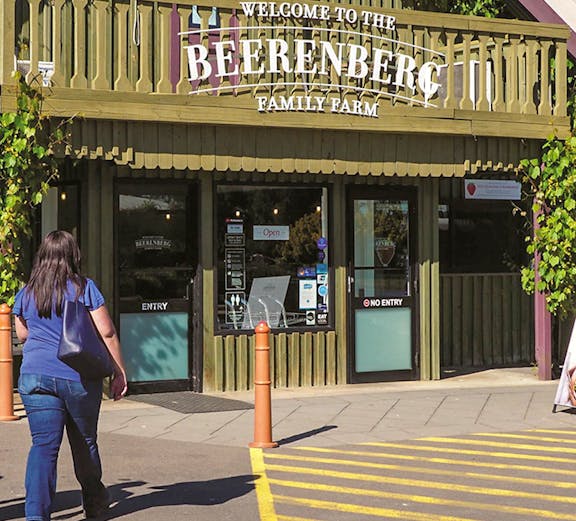 Beerenberg Family Farm entrance in Hahndorf, Australia, with visitor approaching.