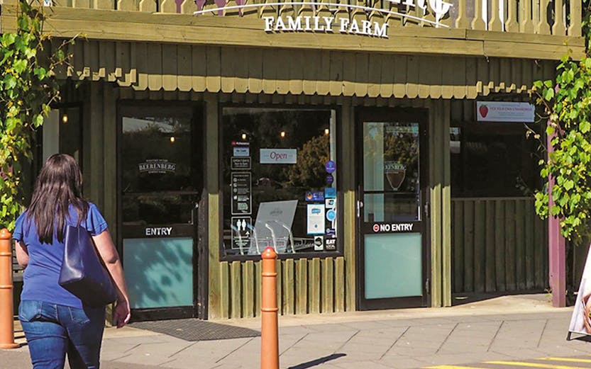 Beerenberg Family Farm entrance in Hahndorf, Australia, with visitor approaching.