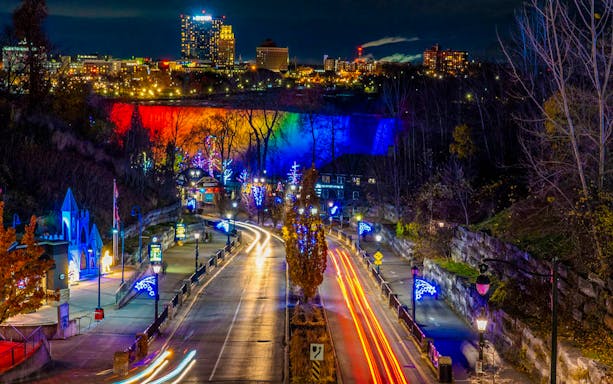 Niagara Falls illuminated during the Niagara Festival of Lights Tour, showcasing vibrant light displays.