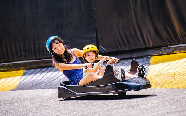 Two people enjoying a ride on the Skyline Luge track.