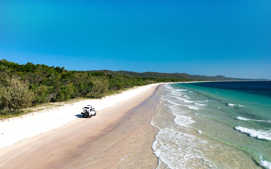 4WD vehicle driving along the beach on Moreton Island, Queensland.