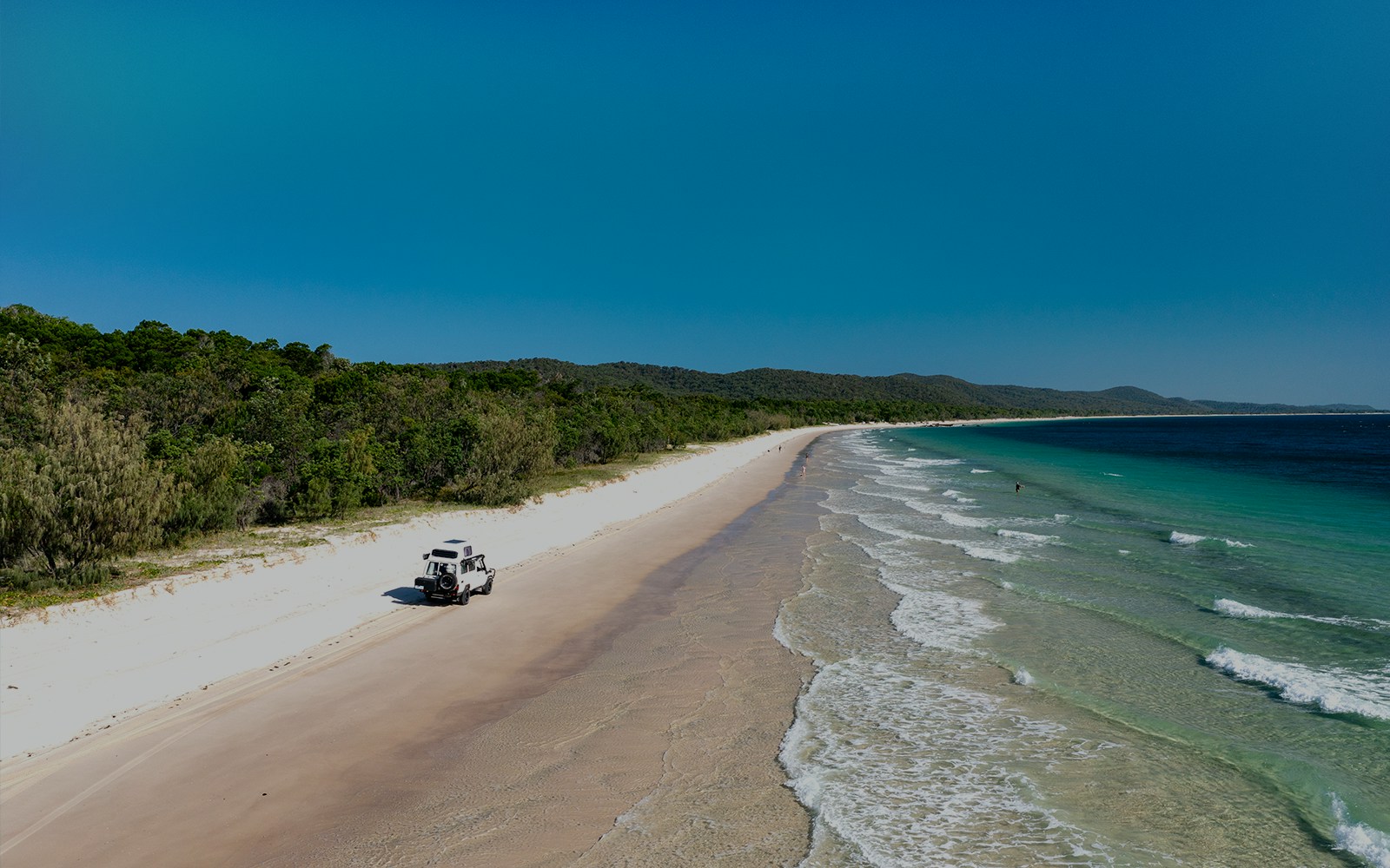 4WD vehicle driving along the beach on Moreton Island, Queensland.