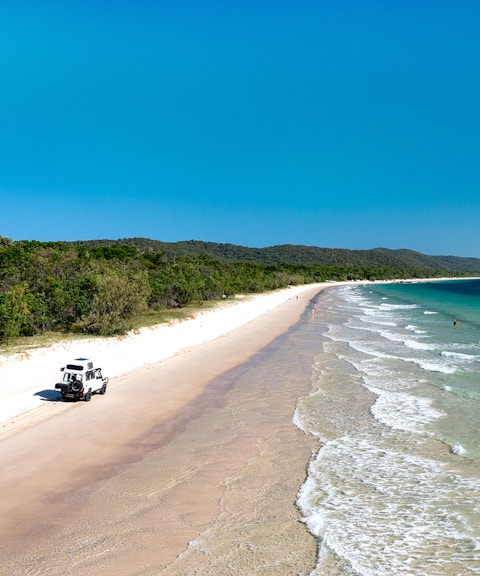 4WD vehicle driving along the beach on Moreton Island, Queensland.