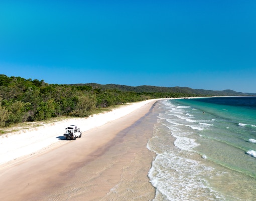 4WD vehicle driving along the beach on Moreton Island, Queensland.