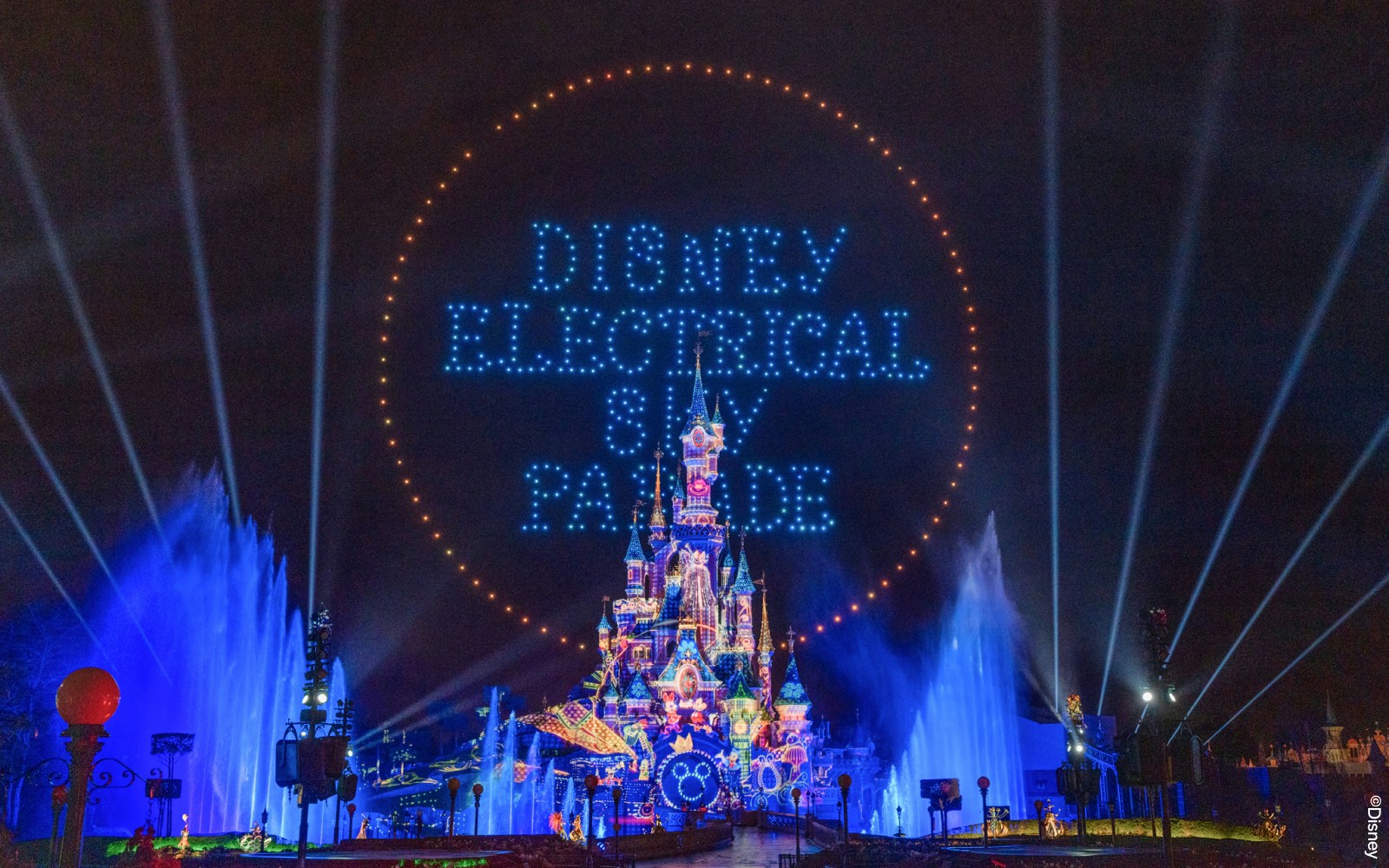 Disneyland Paris Electrical Parade with illuminated floats and characters at night.