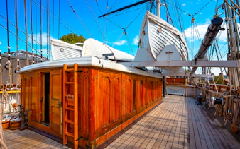 Cutty Sark deck with lifeboats and wooden cabin, Greenwich, London, UK.