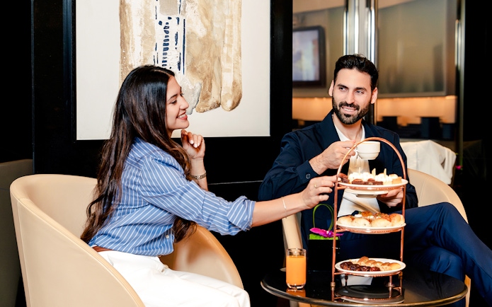 Couple enjoying afternoon tea at Burj Khalifa Level 152 Lounge.