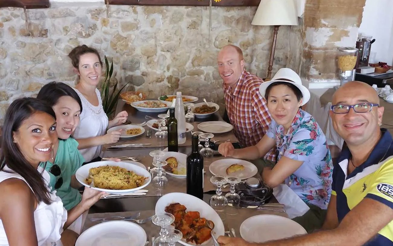 Group enjoying a meal on the Erice & Marsala tour, featuring local wine and cuisine.