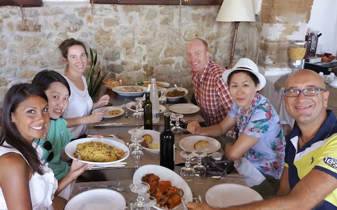 Group enjoying a meal on the Erice & Marsala tour, featuring local wine and cuisine.