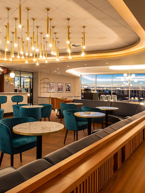 Plaza Premium Lounge seating area at Edinburgh Airport with bar and modern decor.