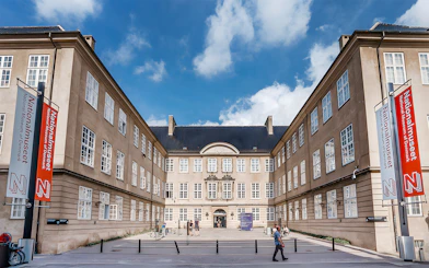 Exterior view of the National Museum of Denmark with entrance and banners.