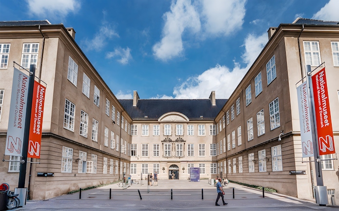 Exterior view of the National Museum of Denmark with entrance and banners.