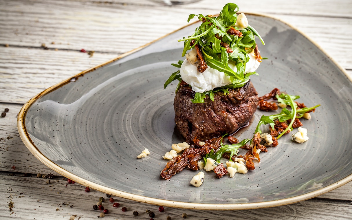 Steak topped with arugula and cheese, part of Moulin Rouge Valentine's Day dinner.