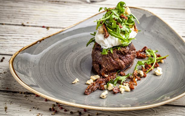 Steak topped with arugula and cheese, part of Moulin Rouge Valentine's Day dinner.