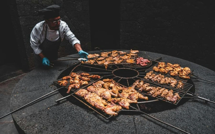 Chef grilling meat over volcanic heat at Timanfaya National Park evening tour.
