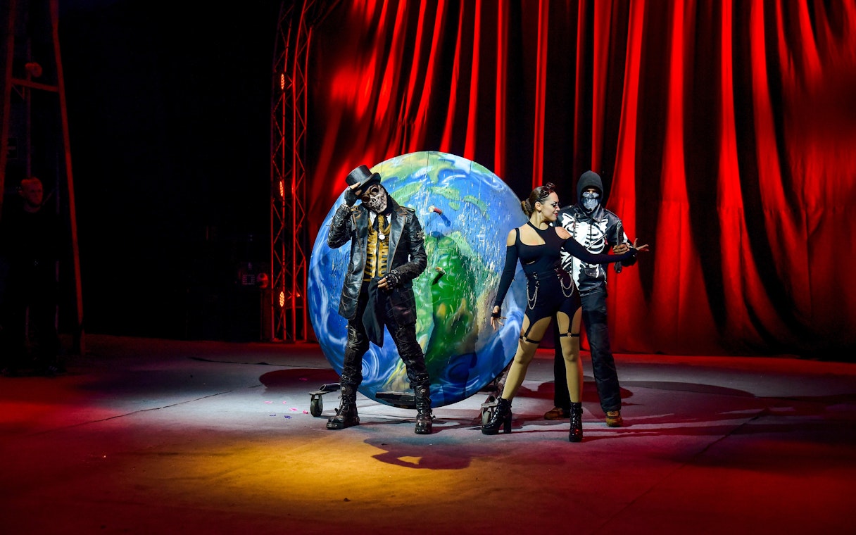 Performers in costume at Aqua Circus Phuket with a globe backdrop.