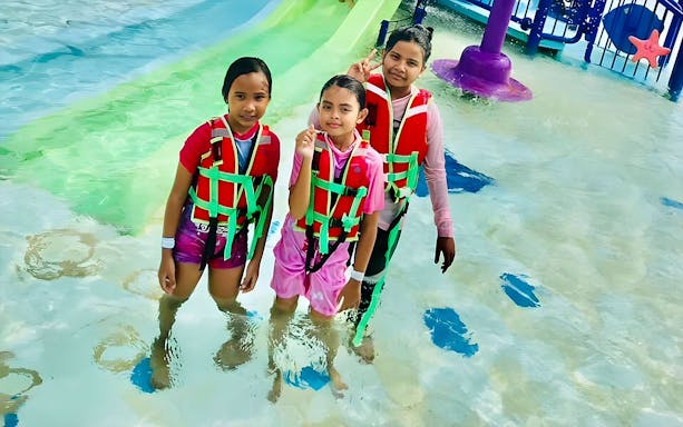 Children in life jackets standing in shallow water at Langkawi Marine Park.