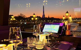 Eiffel Tower view from Bus Toqué Paris at night with dining setup.