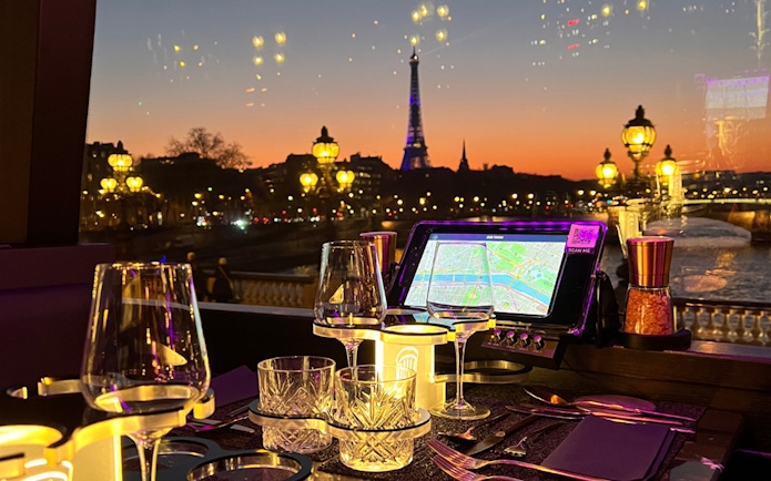 Eiffel Tower view from Bus Toqué Paris at night with dining setup.