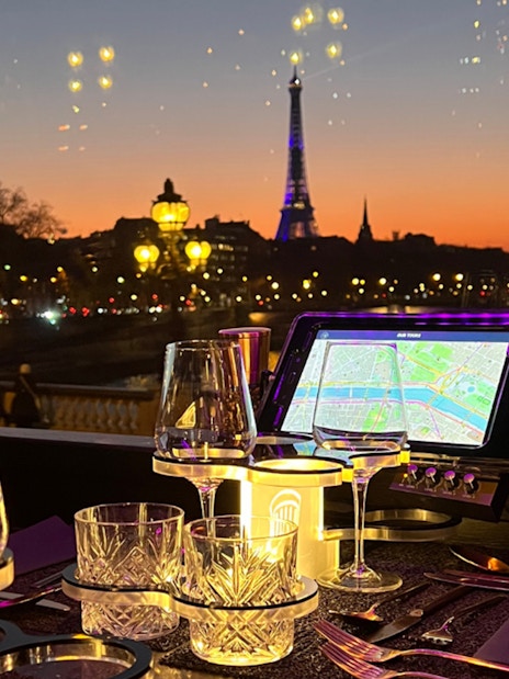 Eiffel Tower view from Bus Toqué Paris at night with dining setup.