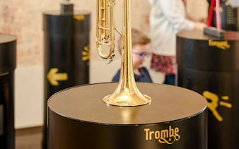 Guests viewing a trumpet exhibit at Mozart Interactive Museum in Prague.
