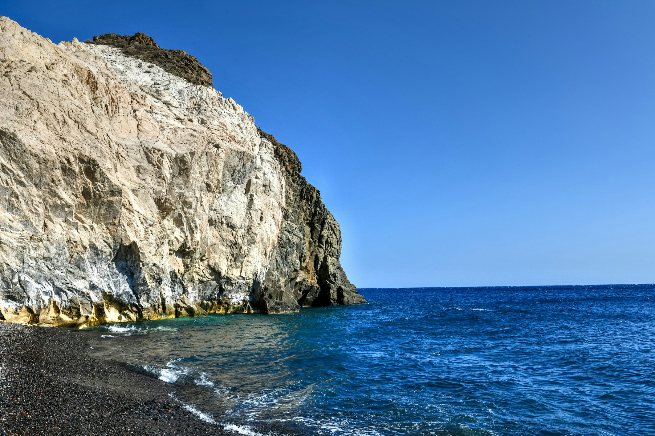 Rocky coastline and blue sea at Mesa Pigadia, Santorini.