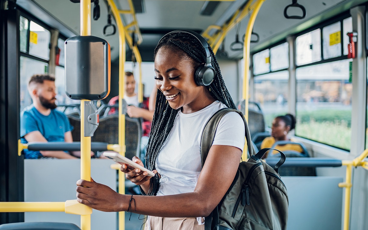 Person using phone on London bus transfer.