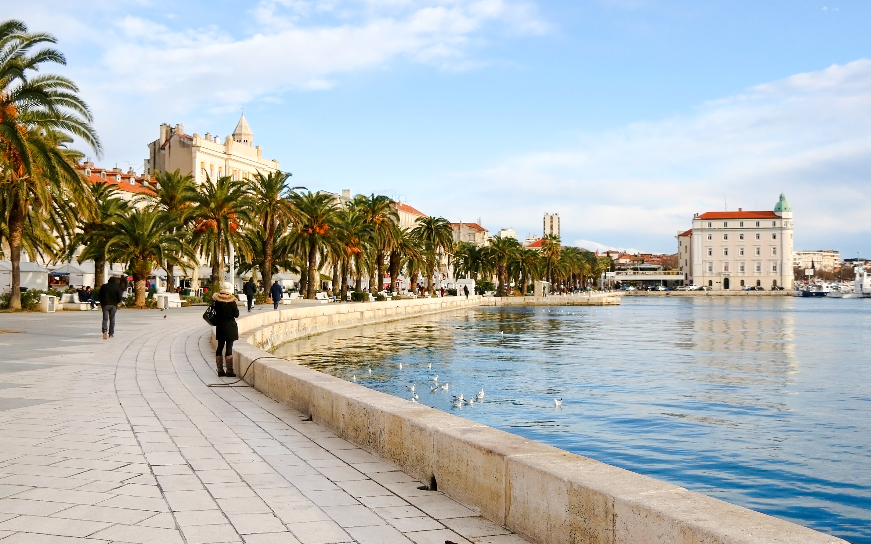 Riva promenade in Split, Croatia with palm trees and waterfront walkway.