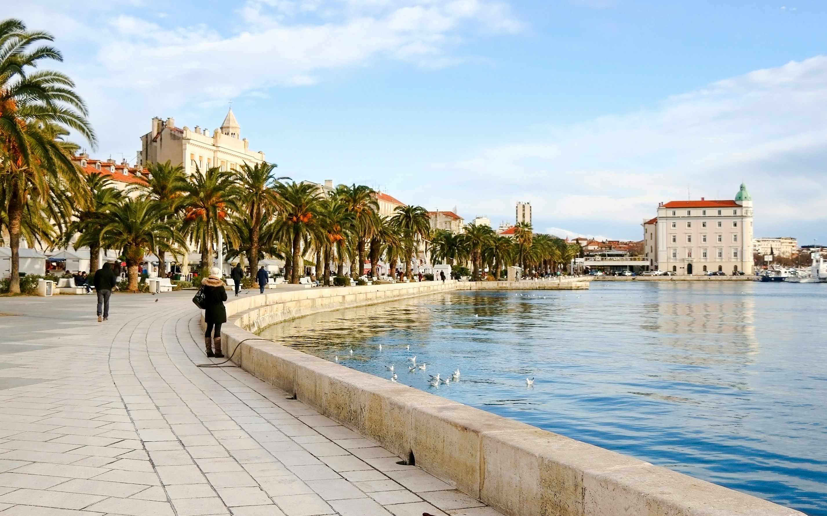Riva promenade in Split, Croatia with palm trees and waterfront walkway.