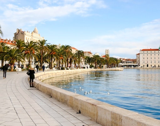 Riva promenade in Split, Croatia with palm trees and waterfront walkway.