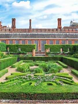 Hampton Court Palace garden with intricate hedges and flowers, Magic Gardens tour.