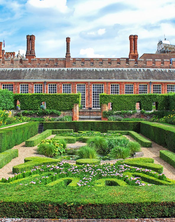 Hampton Court Palace garden with intricate hedges and flowers, Magic Gardens tour.