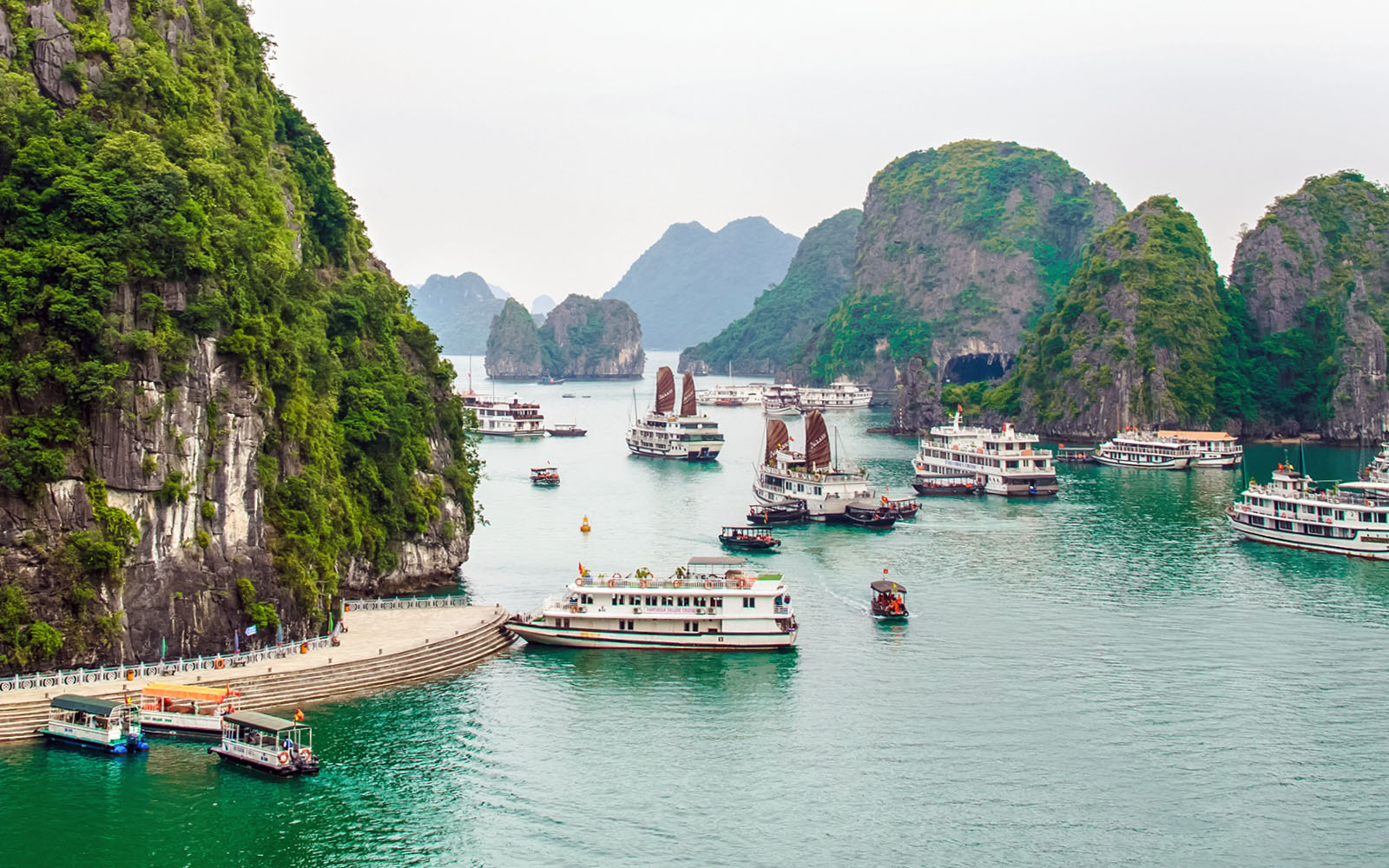 Cruise ships sailing through limestone islands in Ha Long Bay, Vietnam.