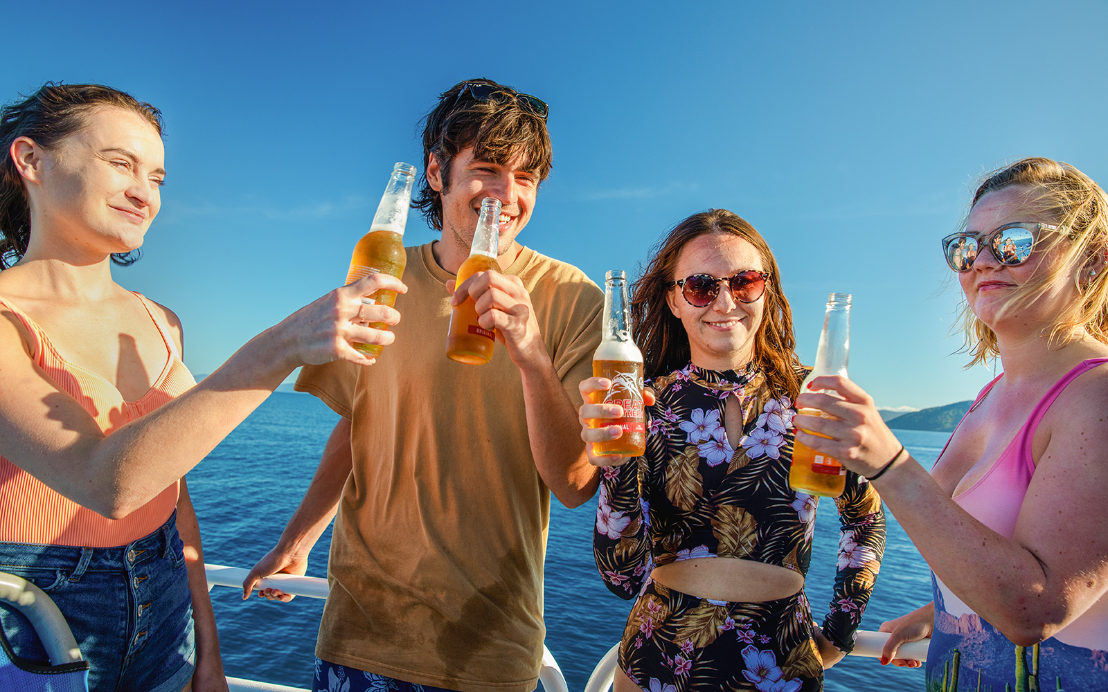 Group enjoying drinks on a boat during Fitzroy Island adventure.