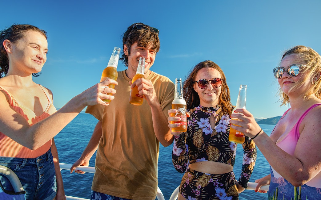 Group enjoying drinks on a boat during Fitzroy Island adventure.