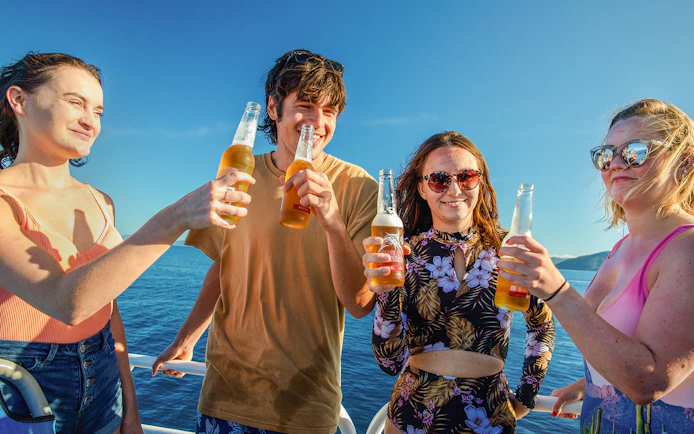 Group enjoying drinks on a boat during Fitzroy Island adventure.