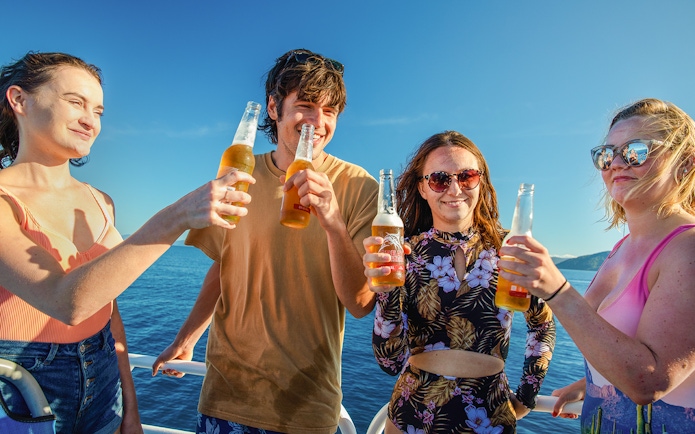 Group enjoying drinks on a boat during Fitzroy Island adventure.