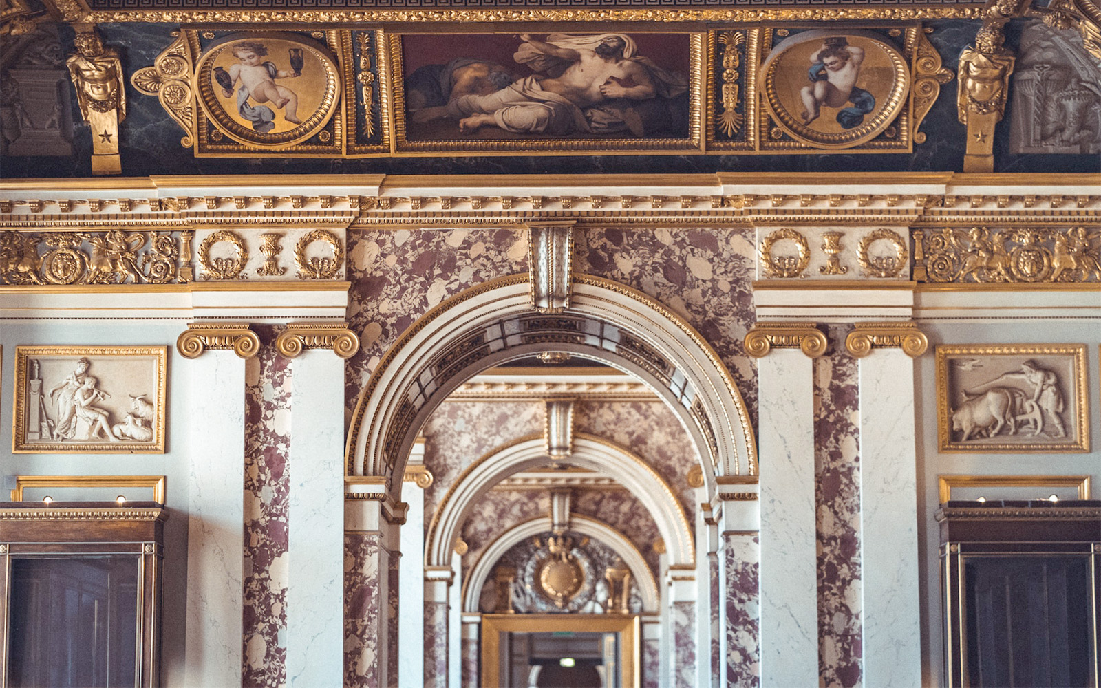 Visitantes explorando inscripciones antiguas en el Museo del Louvre de París, una experiencia cultural única.