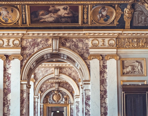 Tourists exploring ancient inscriptions at the Louvre Museum in Paris, a unique cultural experience