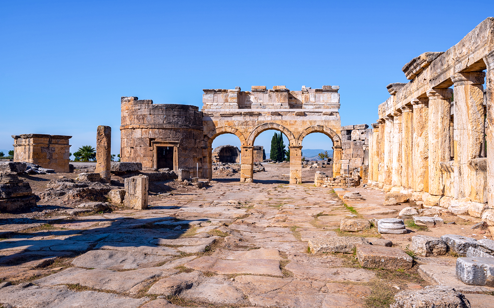 Hierapolis city gate ruins with stone arches and columns in Turkey.