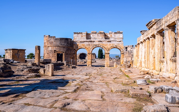 Hierapolis city gate ruins with stone arches and columns in Turkey.