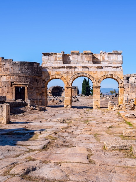 Hierapolis city gate ruins with stone arches and columns in Turkey.