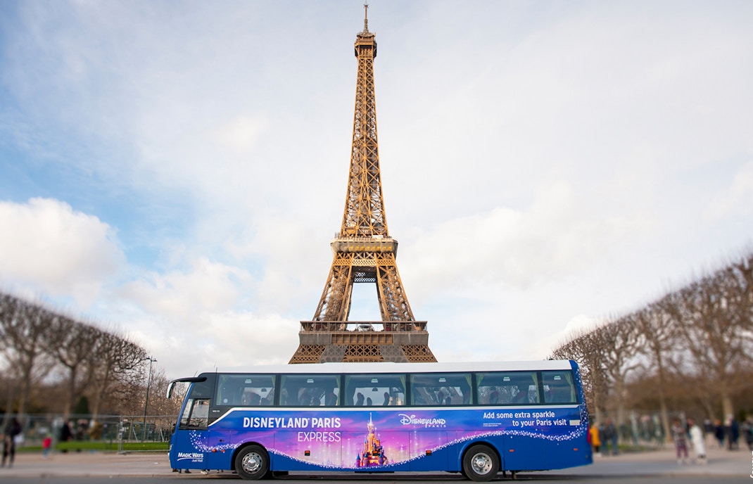 Shuttle bus in front of Eiffel Tower for Disneyland Paris tour.