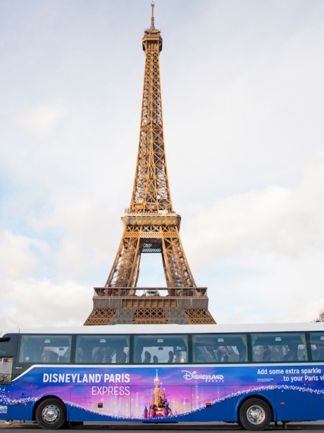 Shuttle bus in front of Eiffel Tower for Disneyland Paris tour.