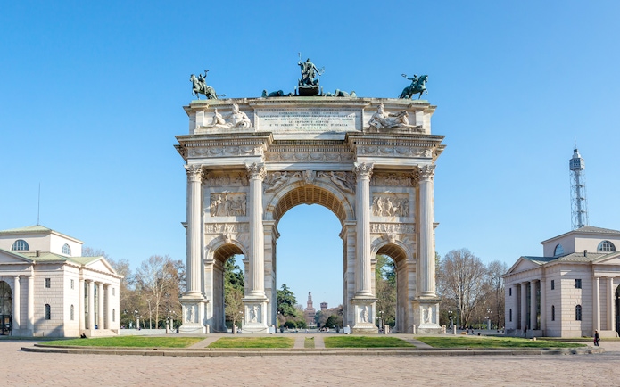 Arch of Peace in Milan with surrounding neoclassical buildings and clear sky.