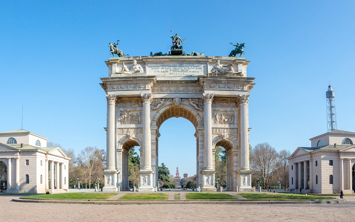 Arch of Peace in Milan with surrounding neoclassical buildings and clear sky.
